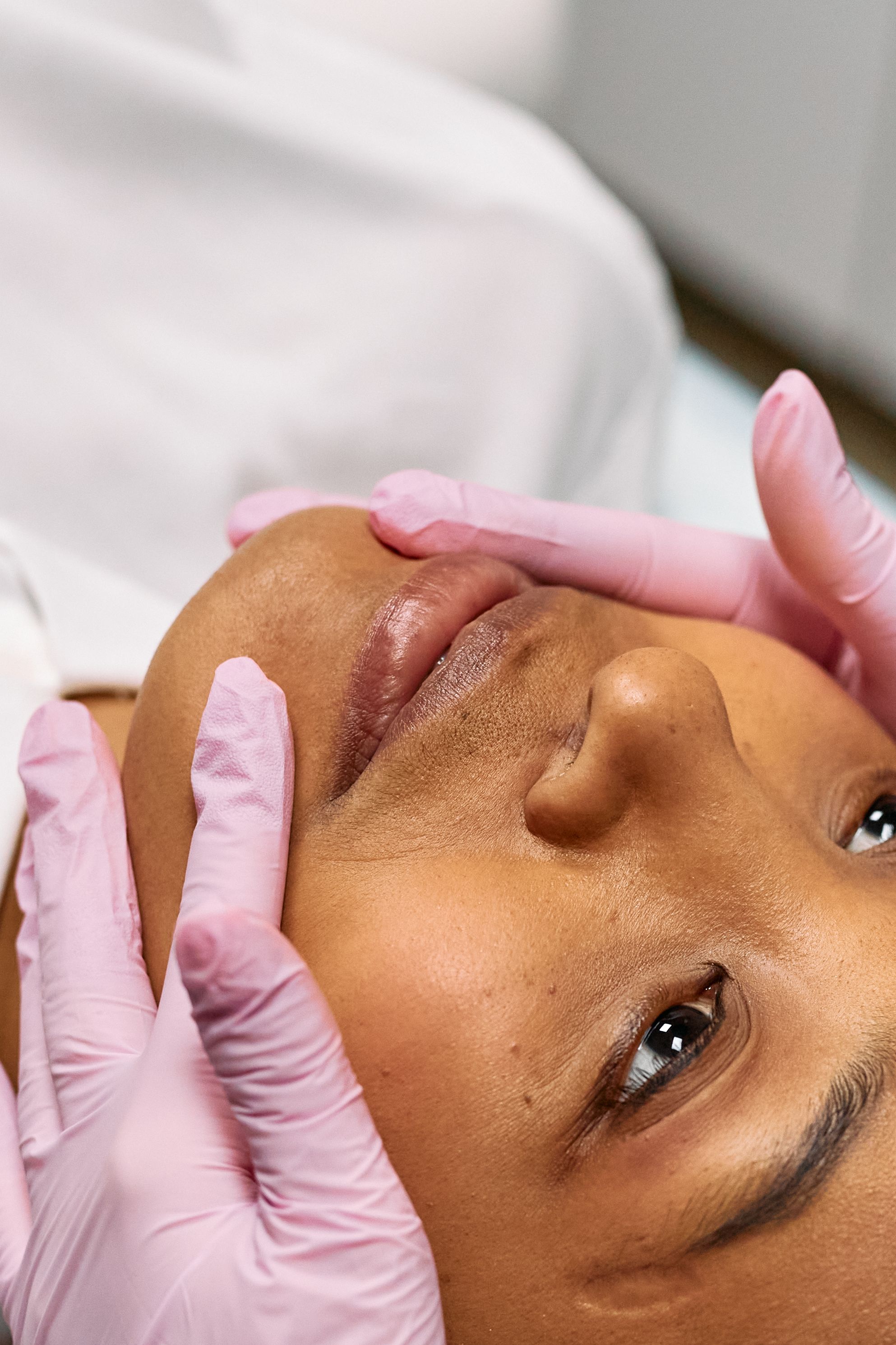 Client receiving a calm, hands-on facial treatment